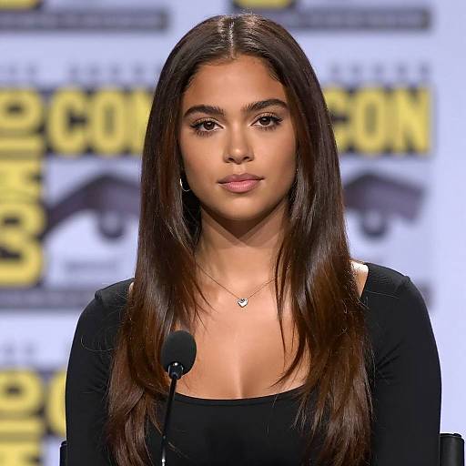 Young woman with heart necklace speaking at event