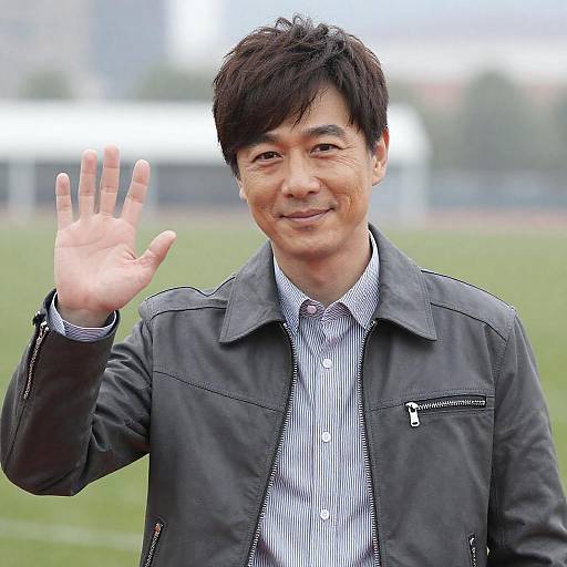 Smiling Asian Man Waving Outdoors