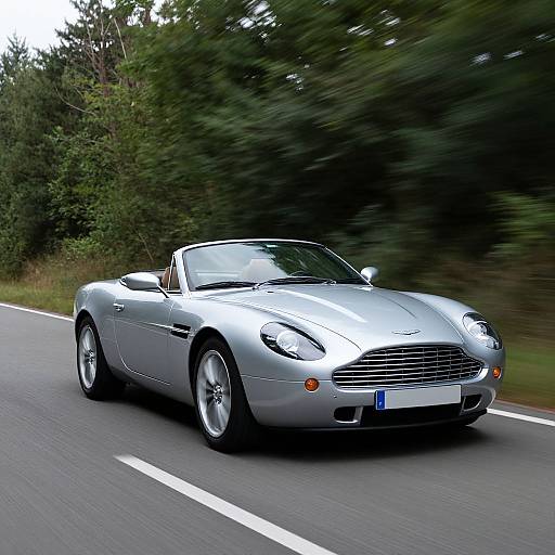 Photograph of a sleek, silver convertible sports car with a Mercedes-Benz emblem, speeding on a winding, tree-lined road.