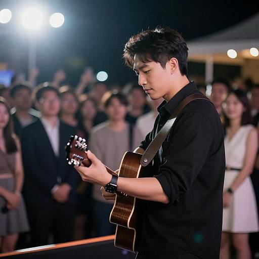 Male Guitarist on Dimly Lit Stage