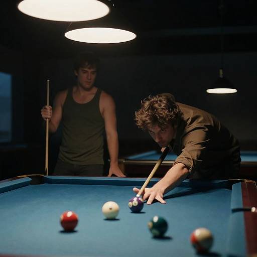 Two Men Playing Pool in Dimly Lit Room