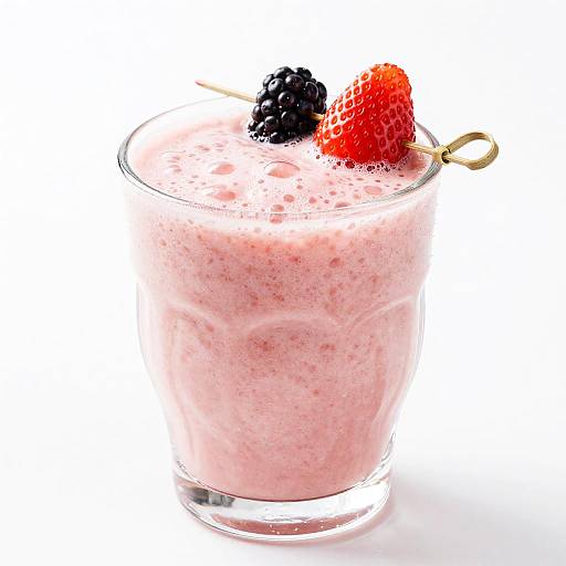 Photograph of a pink, textured smoothie in a clear glass, topped with a blackberry, red strawberry, and gold-handled straw.