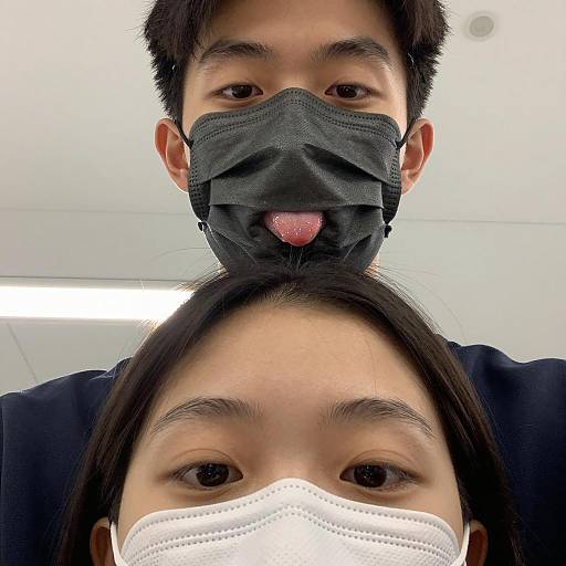 Two people wearing face masks posing for selfie