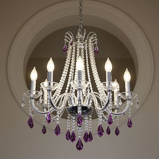 Photograph of an ornate crystal chandelier with five lit white candles, purple gemstone pendants, and intricate beaded drapery, hanging