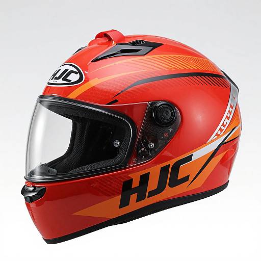 Photograph of a bright red racing helmet with black and orange accents, clear visor, and 