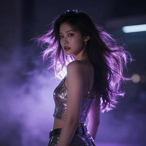 Photograph of an Asian woman with long purple-lit hair, wearing a sparkly silver crop top, standing in a foggy, dimly lit