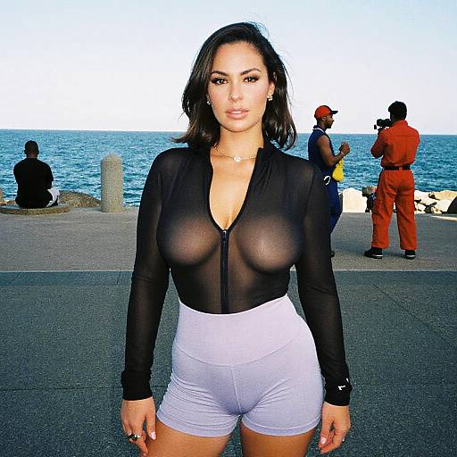 Photograph of a Latina woman with medium skin tone, black hair, wearing a sheer black top revealing her breasts and white high-waisted shorts,