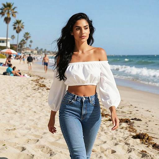 Photograph of a confident woman with long black hair, wearing an off-shoulder white crop top and high-waisted blue jeans, walking on