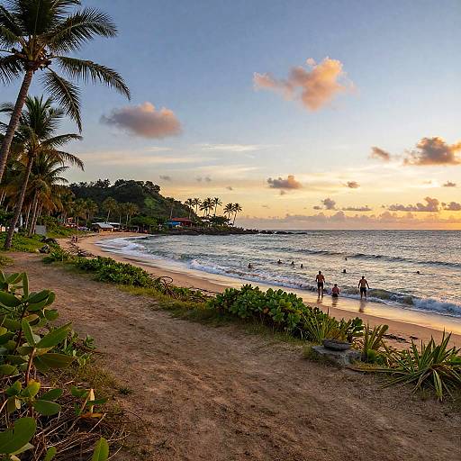 Photograph of a tropical beach at sunset, with palm trees, greenery, gentle waves, people wading, and a vibrant orange-blue sky.