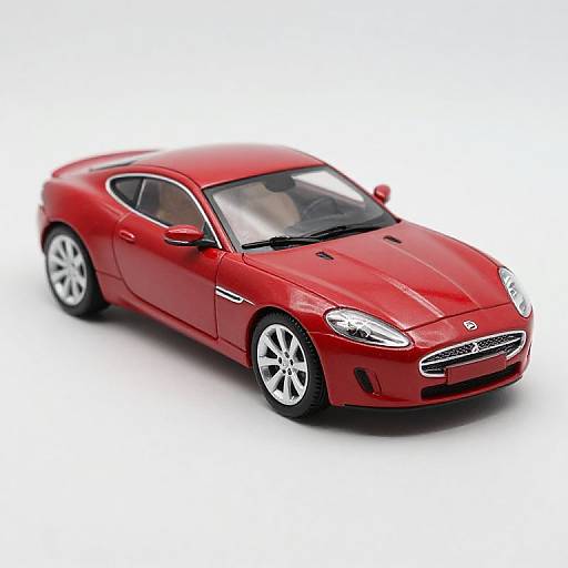 Photograph of a sleek, red sports sedan with silver wheels, black-tinted windows, and a stylish front grille, set against a plain white