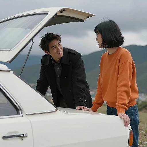 Couple by White Vintage Car with Open Trunk