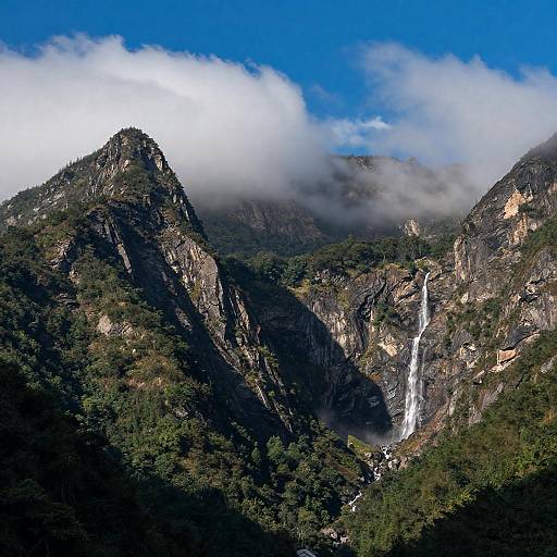 Sunlit Rugged Mountain Range with Waterfall