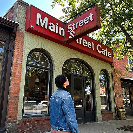 Photograph of a woman in a blue denim jacket standing outside the 
