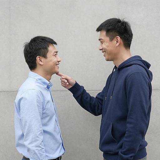 Two Asian men smiling and interacting