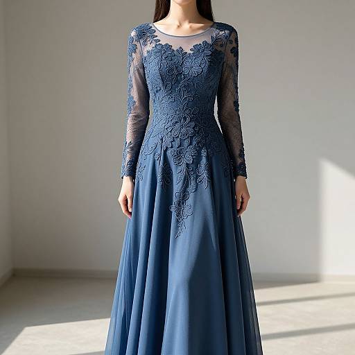 Photograph of a woman in a floor-length, long-sleeved, navy blue lace gown with sheer sleeves, standing in a sunlit, minimal