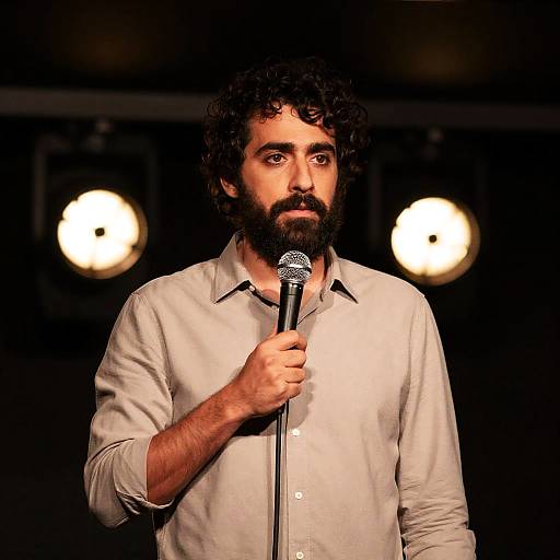 Man Speaking on Stage with Microphone