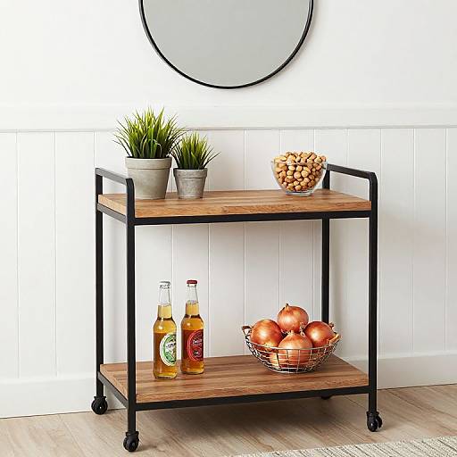 Photograph of a modern wooden and black metal bar cart with potted plant, pinecone bowl, orange apples, and two bottles. White paneled