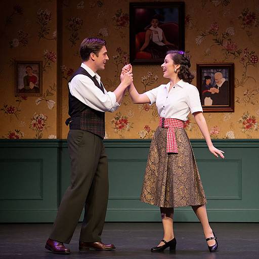 Photograph of a 1940s-style dance duo, man in vest and black pants, woman in white blouse and checked skirt, dancing on stage