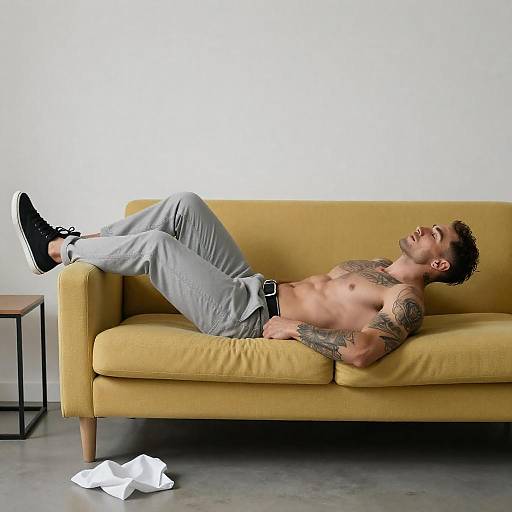 Tattooed Man Reclining on Yellow Couch