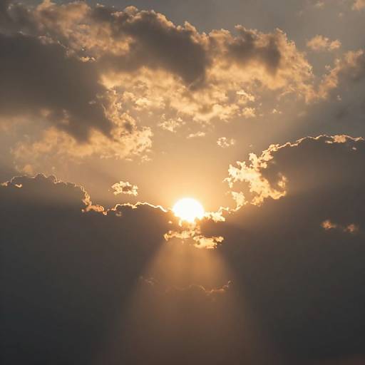 Photograph of a sunsetting sky with golden light piercing through dark, textured clouds, creating dramatic rays and a warm, ethereal glow.