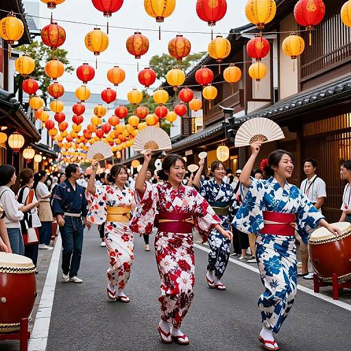 Photograph of Asian women in floral kimonos, dancing with fans in a street festival, illuminated by red and orange lanterns.