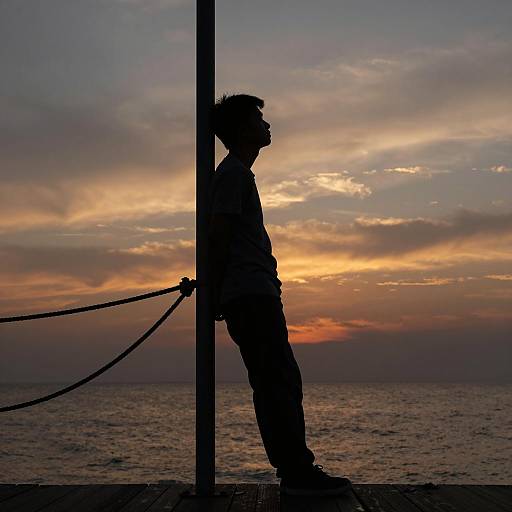 Silhouetted Man on Sunset Pier