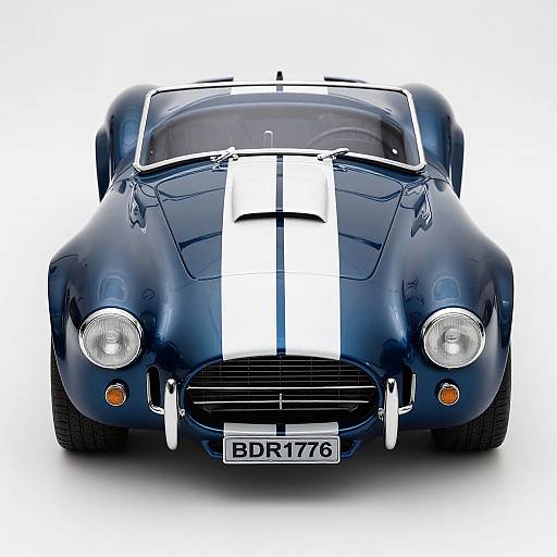 Photograph of a glossy, dark blue vintage race car with white racing stripes, front view, license plate 
