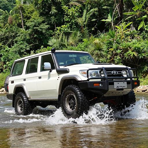 Photograph of a white, rugged Toyota 4Runner with large black tires splashing through a shallow, muddy river in a lush, green jungle.