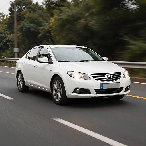 Photograph of a white Hyundai sedan driving on a road with blurred green trees in the background, emphasizing speed and motion.