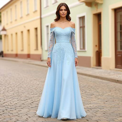Photograph of a brunette woman in an off-shoulder, long-sleeved, light blue lace and tulle wedding dress standing on a cob