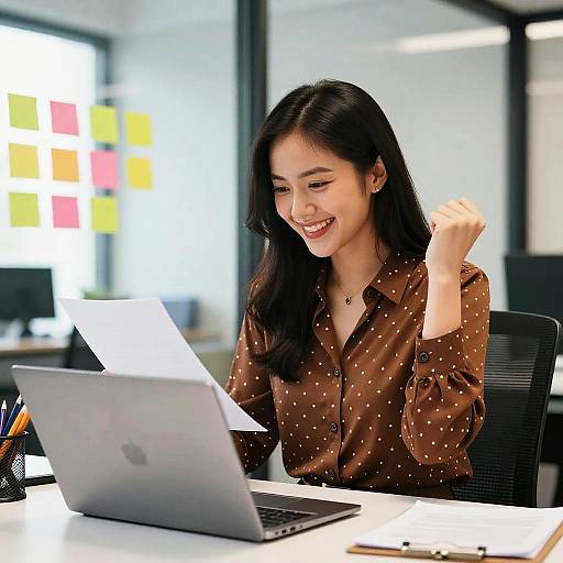 Triumphant Woman at Modern Office Desk