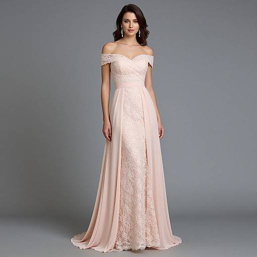 Photograph of a slender woman with dark hair in an off-shoulder, ivory lace and satin bridal gown, standing against a gray studio background.