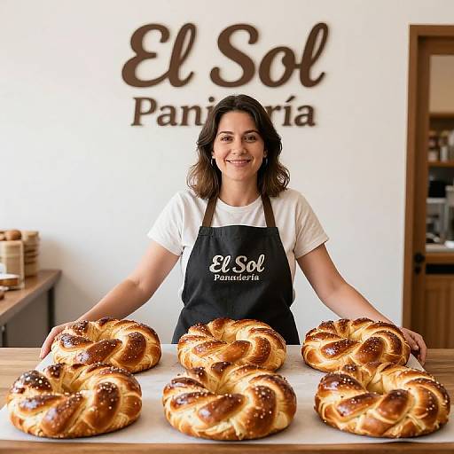 Photograph of a smiling woman with dark hair, wearing a black apron with 