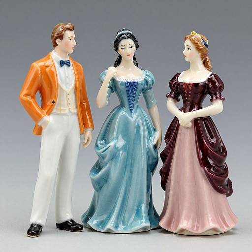 Photograph of three porcelain figurines: a man in an orange jacket and white pants, a woman in a blue ball gown, and another woman in