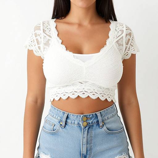 Photograph of a woman with tan skin, wearing a white lace crop top and light blue high-waisted denim jeans, against a plain white background