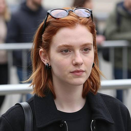 Young red-haired woman with glasses on head