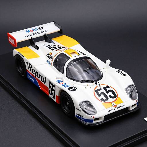 Photograph of a detailed, white and orange race car model with 