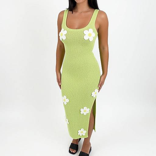 Photograph of a woman wearing a bright yellow, knee-length, crochet dress with white flower patterns, and black open-toe sandals.