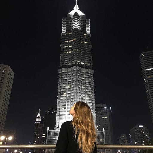 Woman Gazing at Illuminated Skyscraper Night