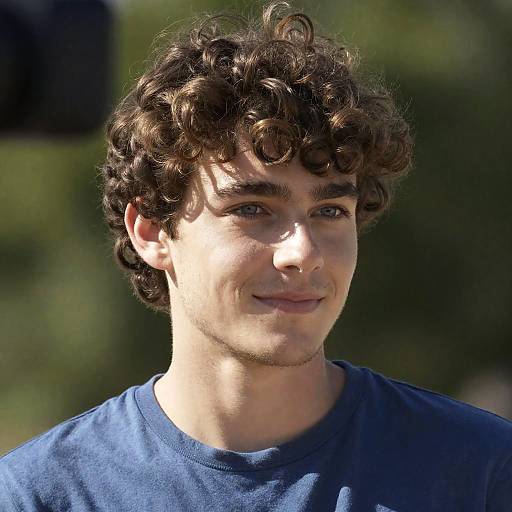 Young Man with Curly Hair Smiling Outdoors
