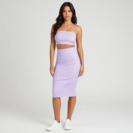Photograph of a curvy woman with long black hair, wearing a white and purple gingham strapless crop top and matching midi skirt, white sneakers