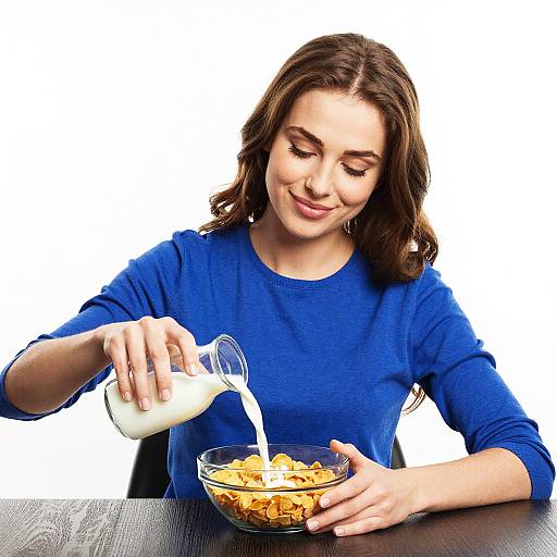 Young Woman Pouring Milk on Cornflakes