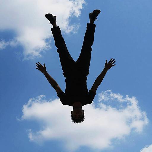 Silhouetted Figure Falling Against Sky