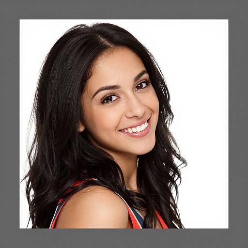 Photograph of a smiling young woman with long, wavy black hair, wearing a red and black sleeveless top, against a white background.