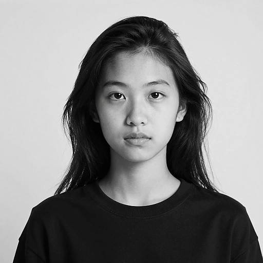 Black-and-white portrait of an Asian woman with long, straight black hair, neutral expression, wearing a plain black shirt, against a white background. Phot