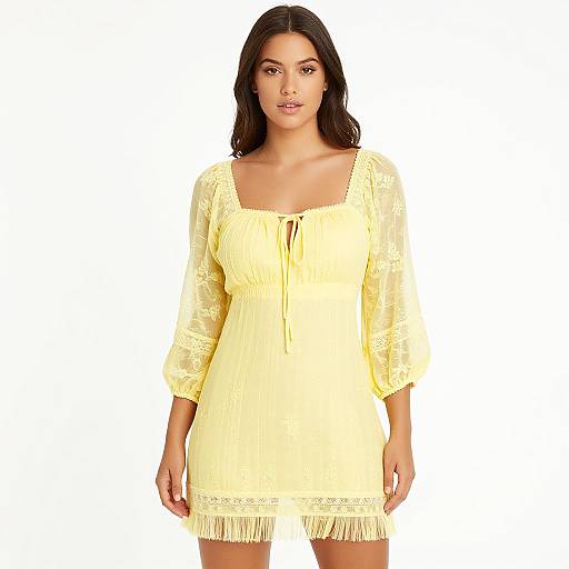 Photograph of a woman with medium brown skin and dark brown hair wearing a yellow, lace-trimmed, long-sleeve, knee-length dress