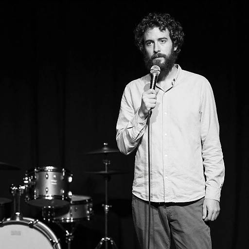 Bearded Man with Microphone on Dark Stage