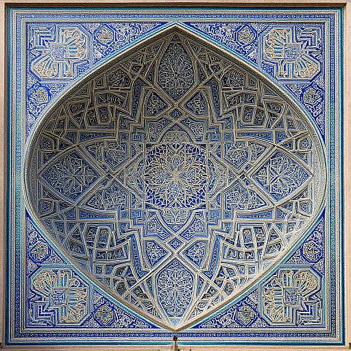 Photograph of intricately detailed, blue and white Islamic geometric and arabesque patterned tile, featuring a central, pointed arch design.