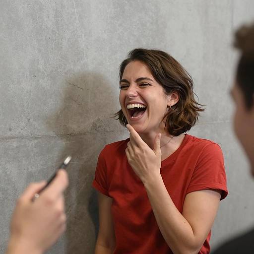 Joyful Woman Laughing Against Gray Wall