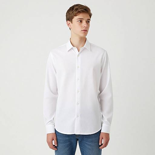 Photograph of a young Caucasian man with short brown hair, wearing a white button-down shirt and blue jeans, standing against a plain white background.